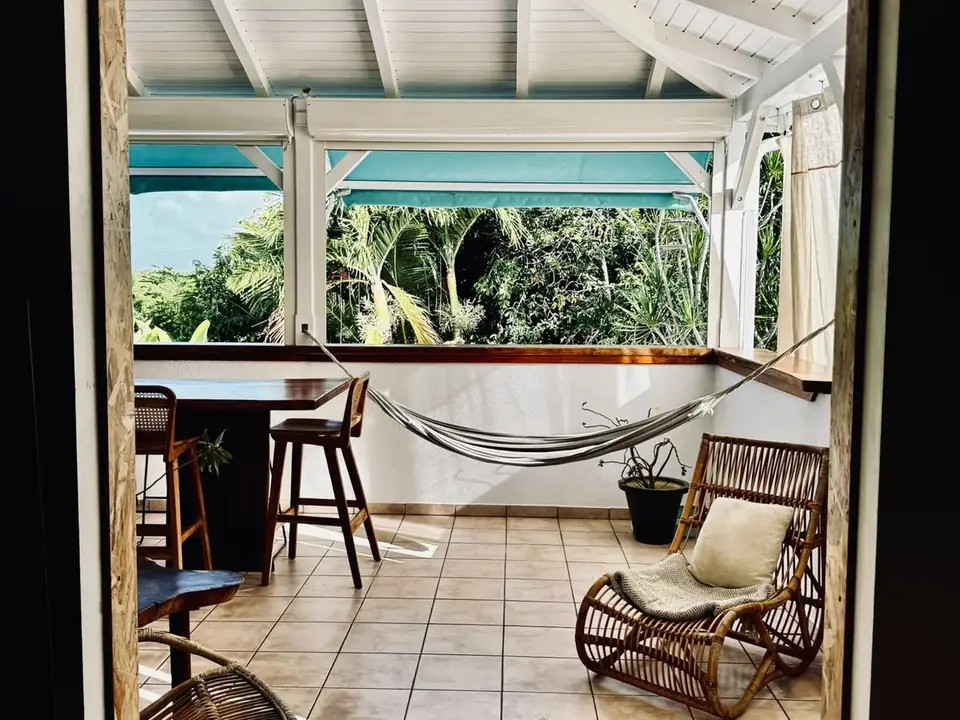 Pièce de vie ouverte sur la végétation tropicale avec hamac